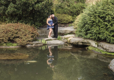 Couple with baby on the way by a pond.